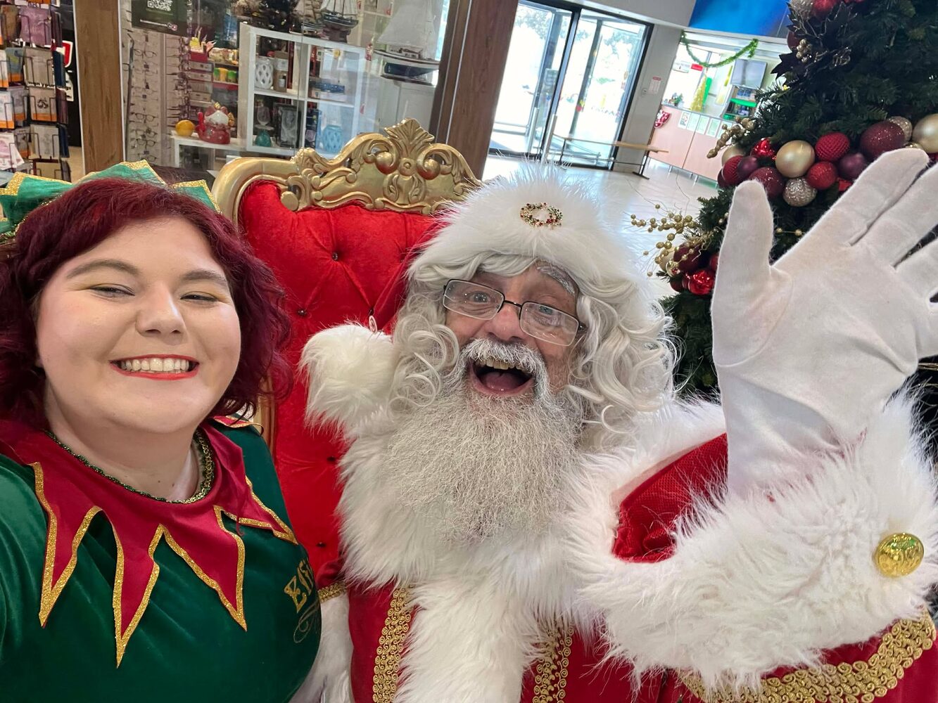 Santa and elf smiling for a selfie in-store