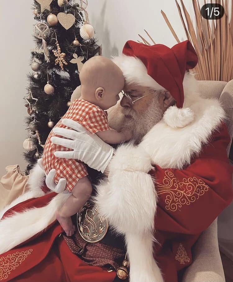 Santa Claus gently cuddling a baby