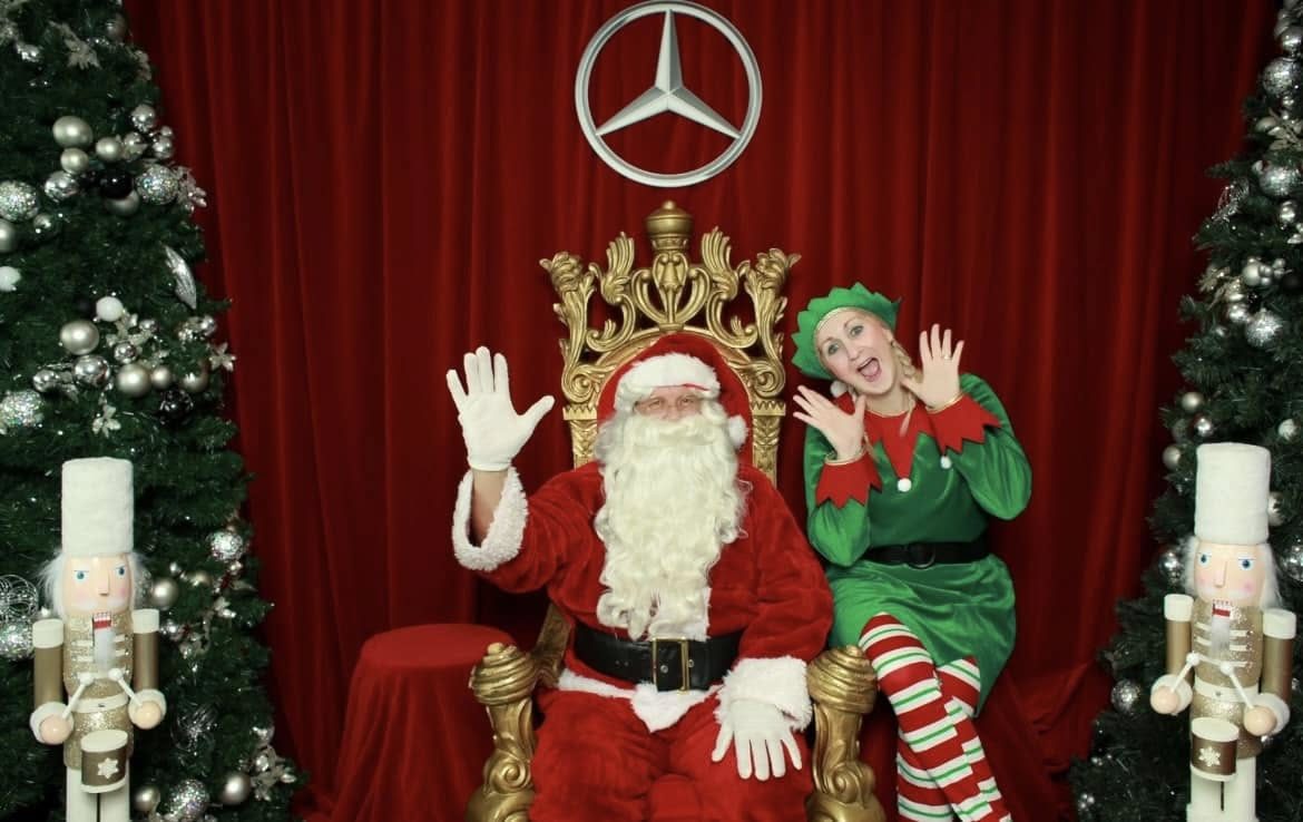 Santa on a festive throne with elves at a Mercedes-Benz showroom