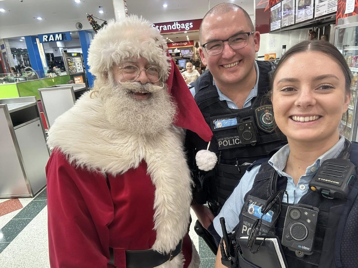 Santa taking a selfie with two police officers