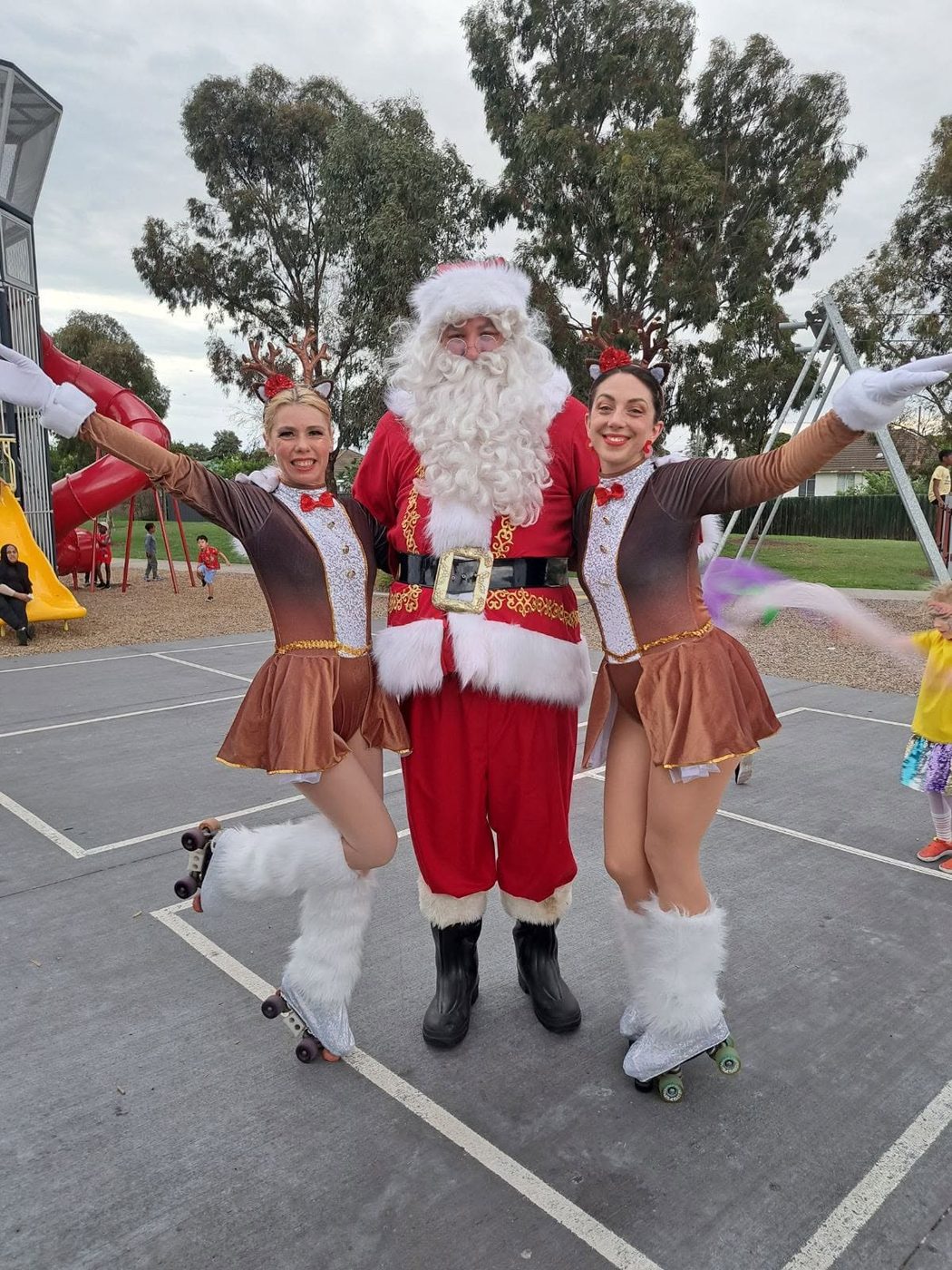 Three professional Santas waving together